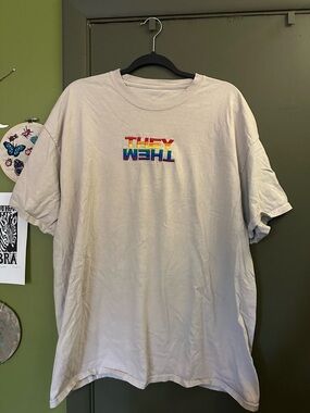 Tan THEY/THEM shirt with rainbow letters